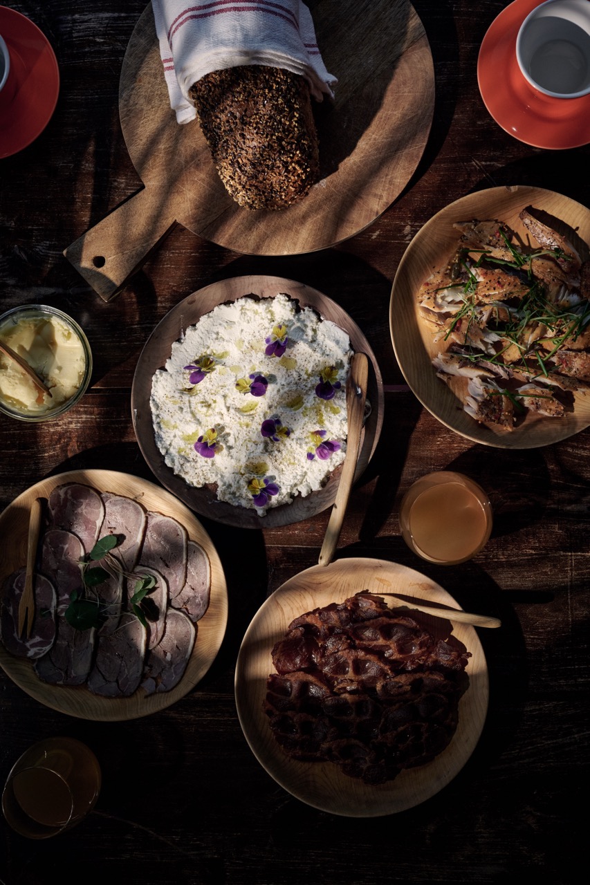 Frokostbuffet på 292 Aurland med tretallerkener fylt med mat stående på et trebord.