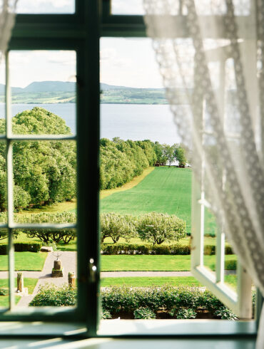 Utsikt fra et vindu på Hoel gård ved Mjøsa.
